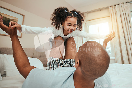 Image of Dad, child and playing on bed flying for fun, quality time or bonding together in home, bedroom or girl in airplane game. Happy, father and daughter in air with knees and arms raised with freedom
