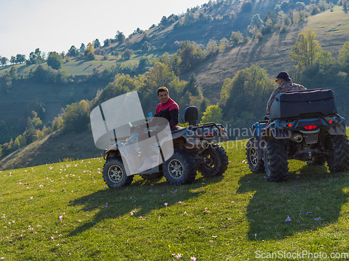 Image of Adventurous driving of ATV motorbikes. Two man driving a quad bike on dangerous roads