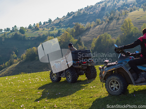 Image of A man driving a quad ATV motorcycle through beautiful meadow landscapes