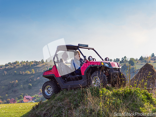 Image of A man driving a quad ATV motorcycle through beautiful meadow landscapes