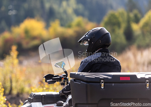 Image of Adventurous driving of ATV motorbikes. A man drives a quad bike on dangerous roads