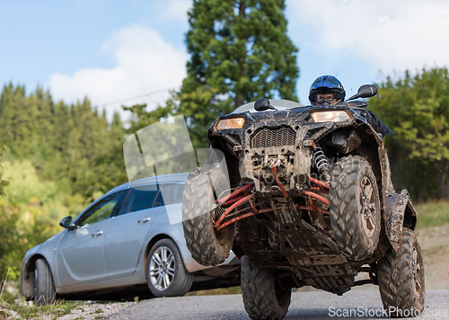 Image of Adventurous driving of ATV motorbikes. A man drives a quad bike on dangerous roads