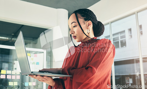 Image of Woman in office with laptop, research and website for ideas at window, website for business plan and brainstorming startup proposal. Thinking, typing and businesswoman on computer for internet search