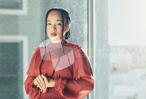 Image of Serious, corporate and portrait of a woman at work for business, professional job or career. Office, young and an employee or worker at a company, agency or workplace by a window and working