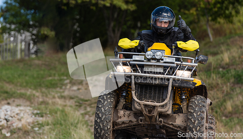 Image of Adventurous driving of ATV motorbikes. A man drives a quad bike on dangerous roads