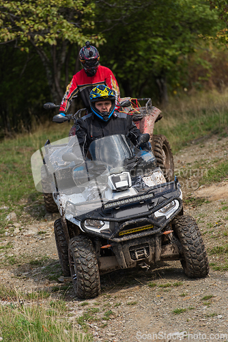 Image of Adventurous driving of ATV motorbikes. A man drives a quad bike on dangerous roads