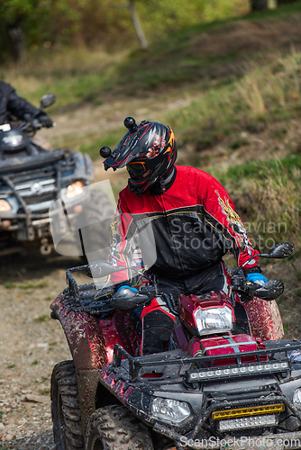 Image of Adventurous driving of ATV motorbikes. A man drives a quad bike on dangerous roads