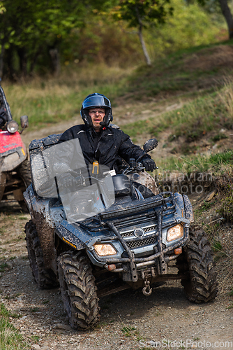 Image of Adventurous driving of ATV motorbikes. A man drives a quad bike on dangerous roads