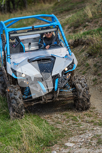 Image of Adventurous driving of ATV motorbikes. A man drives a quad bike on dangerous roads