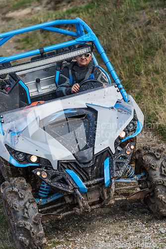 Image of Adventurous driving of ATV motorbikes. A man drives a quad bike on dangerous roads