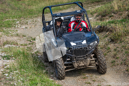 Image of A man driving a quad ATV motorcycle through beautiful meadow landscapes