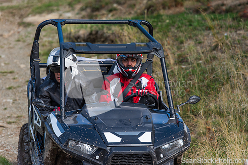 Image of A man driving a quad ATV motorcycle through beautiful meadow landscapes