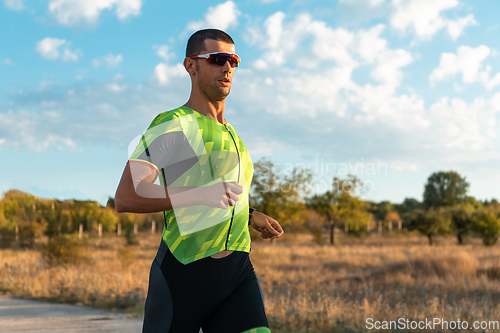 Image of Triathlete in professional gear running early in the morning, preparing for a marathon, dedication to sport and readiness to take on the challenges of a marathon.