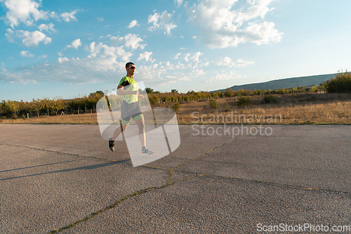 Image of Triathlete in professional gear running early in the morning, preparing for a marathon, dedication to sport and readiness to take on the challenges of a marathon.