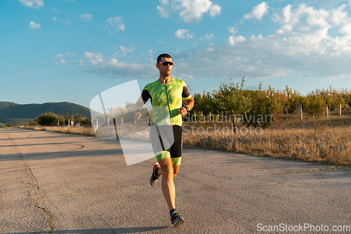 Image of Triathlete in professional gear running early in the morning, preparing for a marathon, dedication to sport and readiness to take on the challenges of a marathon.