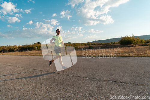 Image of Triathlete in professional gear running early in the morning, preparing for a marathon, dedication to sport and readiness to take on the challenges of a marathon.