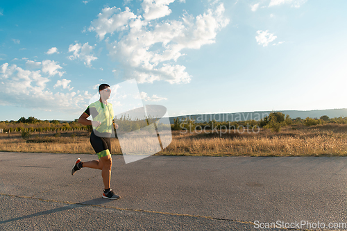 Image of Triathlete in professional gear running early in the morning, preparing for a marathon, dedication to sport and readiness to take on the challenges of a marathon.