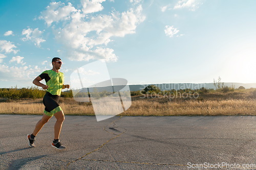 Image of Triathlete in professional gear running early in the morning, preparing for a marathon, dedication to sport and readiness to take on the challenges of a marathon.