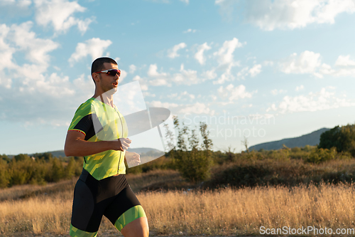 Image of Triathlete in professional gear running early in the morning, preparing for a marathon, dedication to sport and readiness to take on the challenges of a marathon.