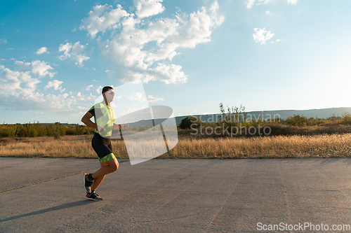 Image of Triathlete in professional gear running early in the morning, preparing for a marathon, dedication to sport and readiness to take on the challenges of a marathon.