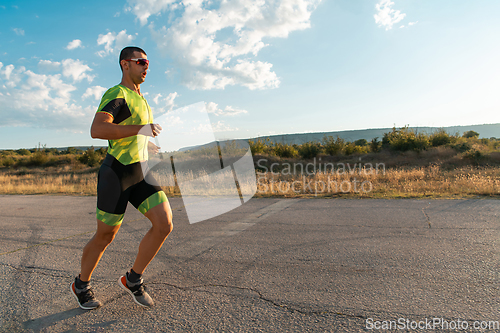 Image of Triathlete in professional gear running early in the morning, preparing for a marathon, dedication to sport and readiness to take on the challenges of a marathon.