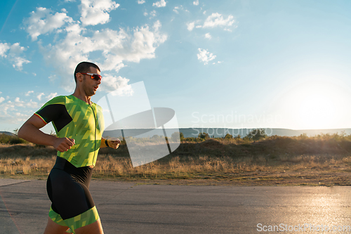 Image of Triathlete in professional gear running early in the morning, preparing for a marathon, dedication to sport and readiness to take on the challenges of a marathon.