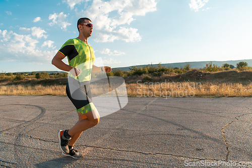 Image of Triathlete in professional gear running early in the morning, preparing for a marathon, dedication to sport and readiness to take on the challenges of a marathon.