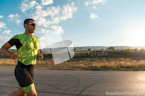 Image of Triathlete in professional gear running early in the morning, preparing for a marathon, dedication to sport and readiness to take on the challenges of a marathon.