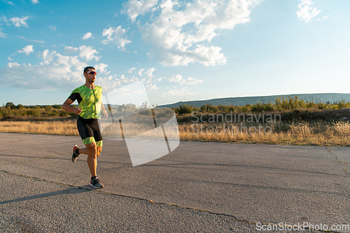 Image of Triathlete in professional gear running early in the morning, preparing for a marathon, dedication to sport and readiness to take on the challenges of a marathon.