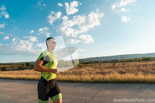 Image of Triathlete in professional gear running early in the morning, preparing for a marathon, dedication to sport and readiness to take on the challenges of a marathon.