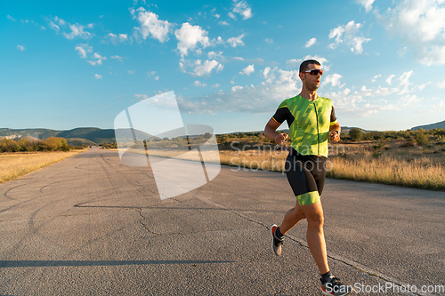 Image of Triathlete in professional gear running early in the morning, preparing for a marathon, dedication to sport and readiness to take on the challenges of a marathon.