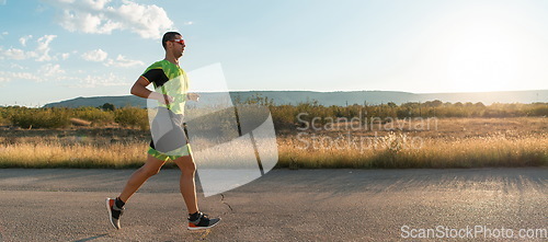 Image of Triathlete in professional gear running early in the morning, preparing for a marathon, dedication to sport and readiness to take on the challenges of a marathon.