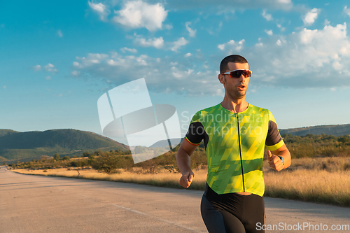 Image of Triathlete in professional gear running early in the morning, preparing for a marathon, dedication to sport and readiness to take on the challenges of a marathon.