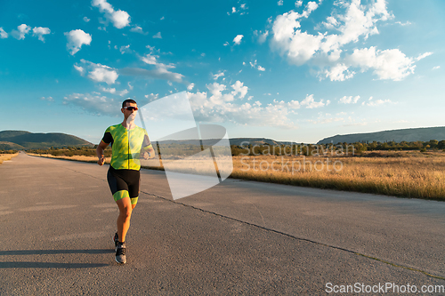 Image of Triathlete in professional gear running early in the morning, preparing for a marathon, dedication to sport and readiness to take on the challenges of a marathon.