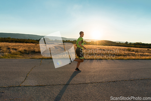 Image of Triathlete in professional gear running early in the morning, preparing for a marathon, dedication to sport and readiness to take on the challenges of a marathon.