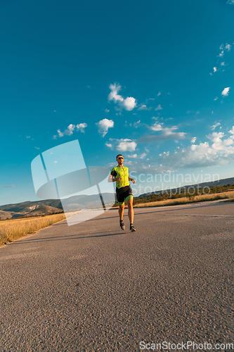 Image of Triathlete in professional gear running early in the morning, preparing for a marathon, dedication to sport and readiness to take on the challenges of a marathon.