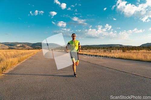 Image of Triathlete in professional gear running early in the morning, preparing for a marathon, dedication to sport and readiness to take on the challenges of a marathon.