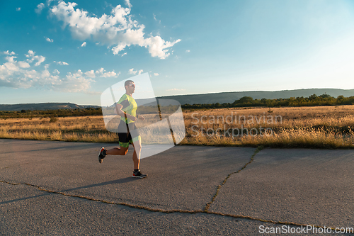 Image of Triathlete in professional gear running early in the morning, preparing for a marathon, dedication to sport and readiness to take on the challenges of a marathon.