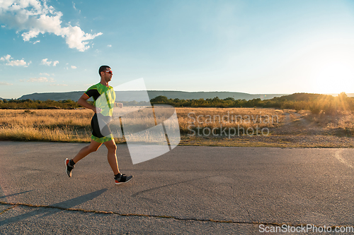 Image of Triathlete in professional gear running early in the morning, preparing for a marathon, dedication to sport and readiness to take on the challenges of a marathon.