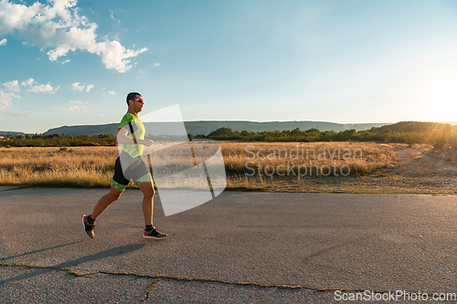 Image of Triathlete in professional gear running early in the morning, preparing for a marathon, dedication to sport and readiness to take on the challenges of a marathon.