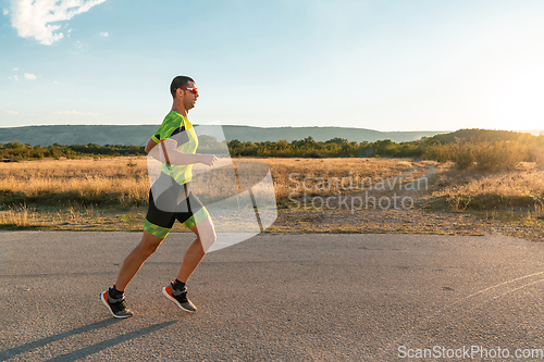 Image of Triathlete in professional gear running early in the morning, preparing for a marathon, dedication to sport and readiness to take on the challenges of a marathon.