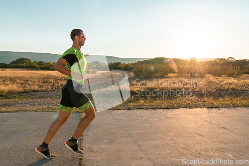 Image of Triathlete in professional gear running early in the morning, preparing for a marathon, dedication to sport and readiness to take on the challenges of a marathon.