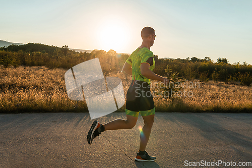 Image of Triathlete in professional gear running early in the morning, preparing for a marathon, dedication to sport and readiness to take on the challenges of a marathon.