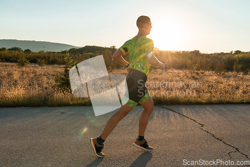 Image of Triathlete in professional gear running early in the morning, preparing for a marathon, dedication to sport and readiness to take on the challenges of a marathon.