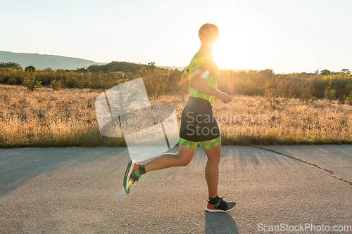 Image of Triathlete in professional gear running early in the morning, preparing for a marathon, dedication to sport and readiness to take on the challenges of a marathon.