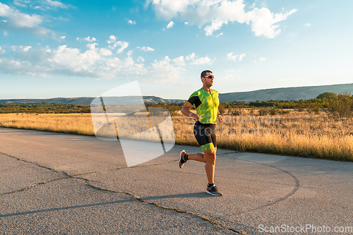 Image of Triathlete in professional gear running early in the morning, preparing for a marathon, dedication to sport and readiness to take on the challenges of a marathon.