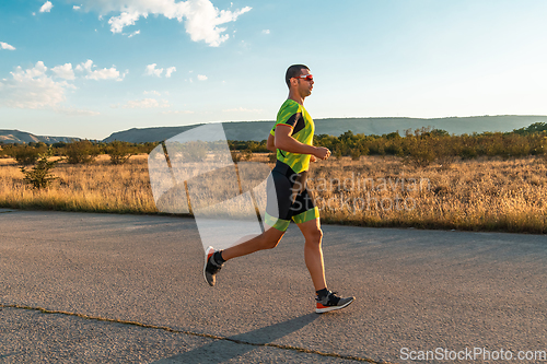 Image of Triathlete in professional gear running early in the morning, preparing for a marathon, dedication to sport and readiness to take on the challenges of a marathon.