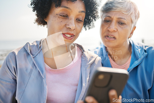 Image of Phone, confused and senior friends on the beach together, browsing social media or reading a text message. Communication, summer and elderly women on the coast with a mobile to search for information