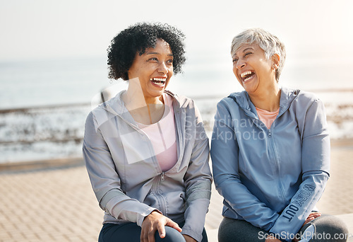 Image of Senior women, laughing and beach with friends, training and sitting in summer outdoor. Exercise, break and mature female in the morning with funny joke and workout for wellness and health by sea