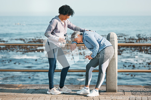 Image of Tired, running and senior friends by the ocean for fitness, exercise and workout. Runner, mature people with sport outdoor on a beach promenade path together for wellness and health on a break